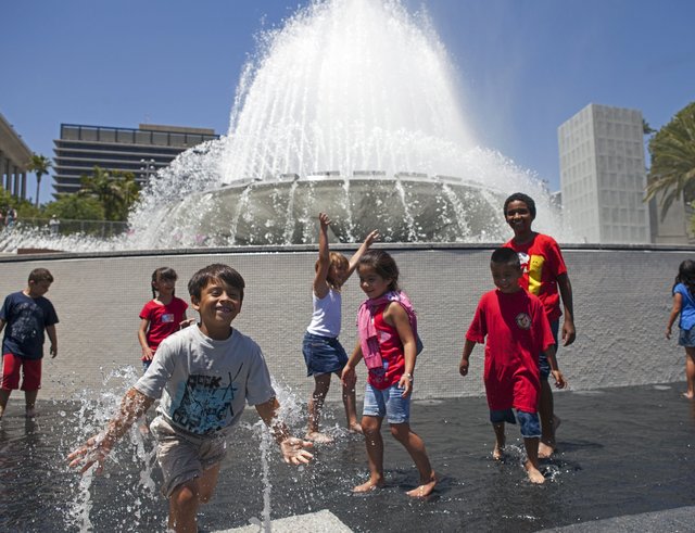 Kids play in front of a large municipal fountain in Grand Park, Los Angeles. 